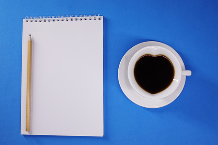 Notepad and coffee on colored background top view, businessの写真素材