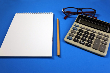 Notepad, pencil and calculator on colored background top view, school, business, education, knowledgeの写真素材