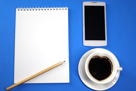 Notepad, coffee and phone on colored background top view, school, business, education, knowledgeの写真素材