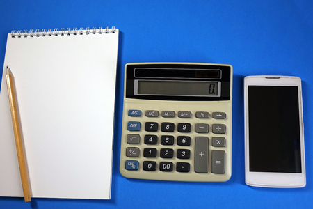 Notepad, pencil and calculator on colored background top view, school, business, educationの写真素材