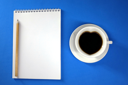 Notepad and coffee on colored background top viewの写真素材