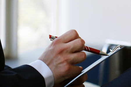 The hand of a young businessman, signing a business contract, close-up .の写真素材