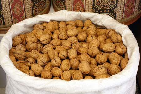 Walnuts in a white bag at the market. Trade.の写真素材