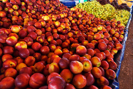Peaches and nectarines on the counter are sold at the grocery store. trade in the market.の写真素材