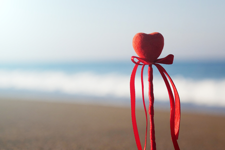 Red heart on the beach.Valentine's day greeting card concept, red heart on pristine sandy beach, honeymoon vacation background.の写真素材