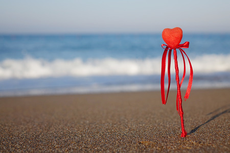 Red heart on the beach.Valentine's day greeting card concept, red heart on pristine sandy beach, honeymoon vacation background.の写真素材