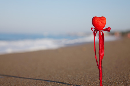 Red heart on the beach.Valentine's day greeting card concept, red heart on pristine sandy beach, honeymoon vacation background.の写真素材
