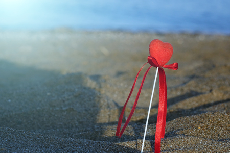 Red heart on the beach.Valentine's day greeting card concept, red heart on pristine sandy beach, honeymoon vacation background.の写真素材