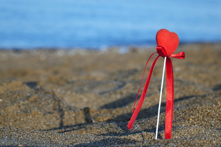 Red heart on the beach.Valentine's day greeting card concept, red heart on pristine sandy beach, honeymoon vacation background.の写真素材