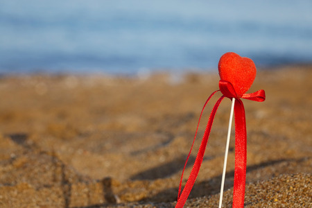 Red heart on the beach.Valentine's day greeting card concept, red heart on pristine sandy beach, honeymoon vacation background.の写真素材