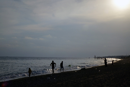 Silhouettes of people on the sea coast. Sunset.の写真素材