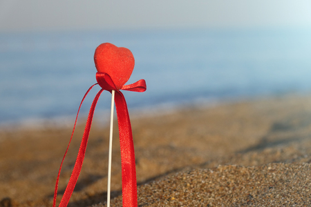 Red heart on the beach.Valentine's day greeting card concept, red heart on pristine sandy beach, honeymoon vacation background.の写真素材