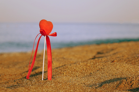 Red heart on the beach.Valentine's day greeting card concept, red heart on pristine sandy beach, honeymoon vacation background.の写真素材