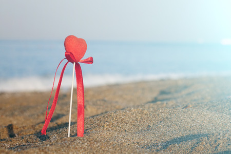 Red heart on the beach.Valentine's day greeting card concept, red heart on pristine sandy beach, honeymoon vacation background.の写真素材