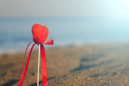 Red heart on the beach.Valentine's day greeting card concept, red heart on pristine sandy beach, honeymoon vacation background.の写真素材