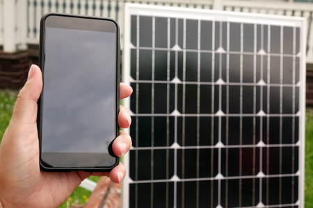Smartphone and solar panel. Energy production technologies.の写真素材