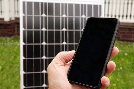 Smartphone and solar panel. Energy production technologies.の写真素材