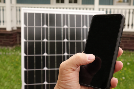 Smartphone and solar panel. Energy production technologies.の写真素材