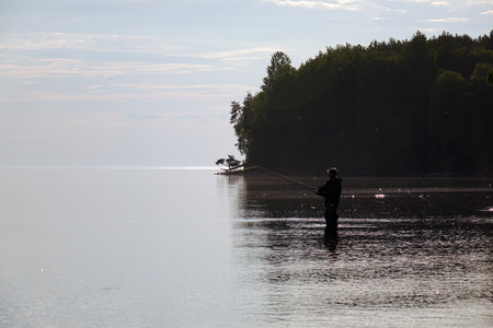 Silhouette of a fisherman at sunset. Fishing on the lake. hobby.の写真素材