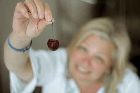 woman lying in bed and eating cherriesの写真素材