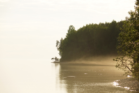 Foggy morning on the lake. Place for textの写真素材