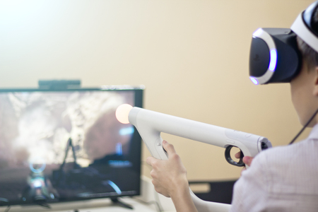 Boy using VR glasses and headset plays computer games.の写真素材