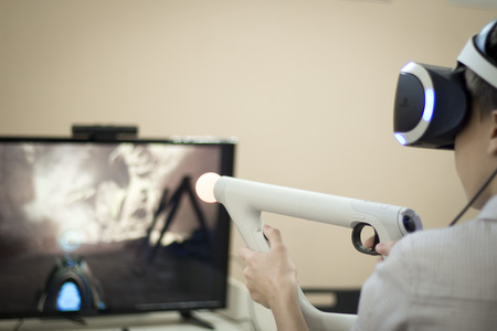 Boy using VR glasses and headset plays computer games. Virtual game.の写真素材
