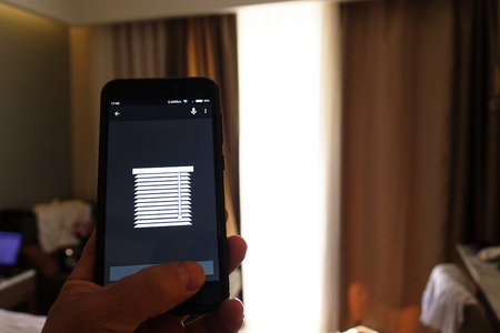 Smart Home: Man Controlling Lights With App On His Phoneの写真素材
