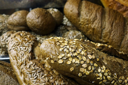 Bread with the addition of seeds and fruits on the table.の写真素材