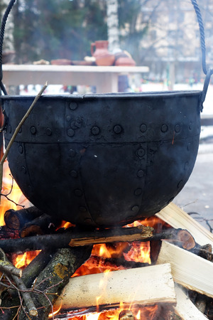 Pot over a fire.Cooking over fire in the woods in winter.の写真素材