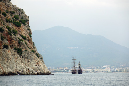 Pirate ship off the coast of Turkey. The Mediterranean sea and steep cliffs. The concept of tourism.の写真素材