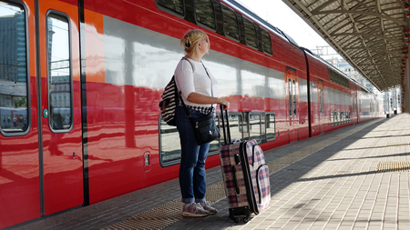 Woman traveler with Luggage arriving at the station waiting for the train. Travel concept for women.の写真素材