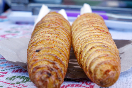 Street food. A spiral fried potato on a two sticks. Crunchy potato, Closeup.の写真素材
