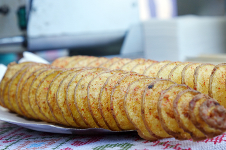 Street food. A spiral fried potato on a two sticks. Crunchy potato, Closeup.の写真素材