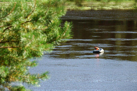 Fisherman in a boat in the middle of the river. Wildlife. Water landscapeの写真素材