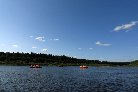 A group of tourists floating on a quiet river on inflatable catamarans, outdoor activitiesの写真素材