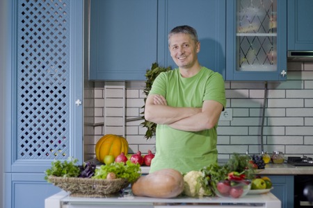 A man in the kitchen prepares vegetarian dishes. Vegetables , ready for cooking.の写真素材