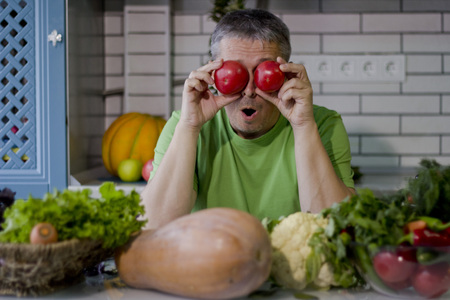 A man in the kitchen prepares vegetarian dishes. Vegetables , ready for cooking.の写真素材