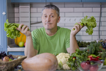 A man in the kitchen prepares vegetarian dishes. Vegetables , ready for cooking.の写真素材