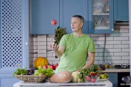 A man in the kitchen prepares vegetarian dishes. Vegetables , ready for cooking.の写真素材