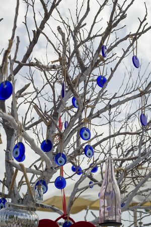 Stone in the form of a blue eye on the tree.Close-up on a tree on chains hang national signs of Turkey-Turkish eyes.の写真素材