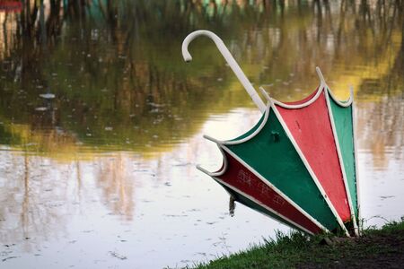 The metal umbrella is used as a flower bed in the city Park . Decoration of flower beds with various plants and umbrellasの写真素材