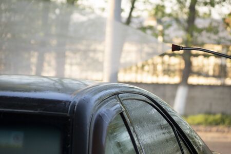 Close-up of a man washing his car with pressurized water in a car wash . Contactless car wash.の写真素材
