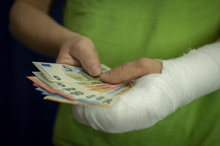 A man with an arm in a cast keeps money from the cost and expense of emergency medical care in a...