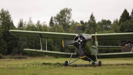 Agricultural airplane stands in a field in the green grass.Aviation.