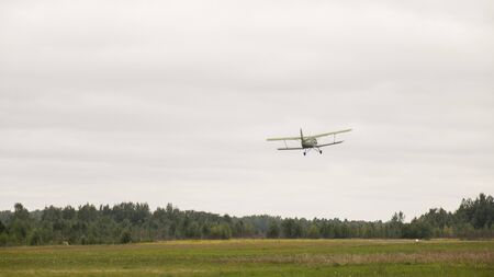 The plane takes off over a green field. Aviation