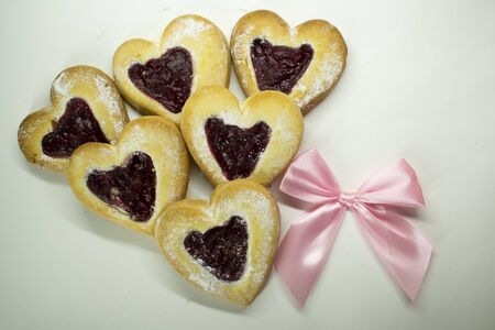 Sugar cookies in the shape of hearts for Valentine's Day. Pink bow on a white background.の写真素材