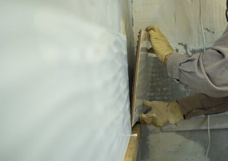 Layout of ceramic tiles on grey cement on the wall. The process of applying tiles .の写真素材