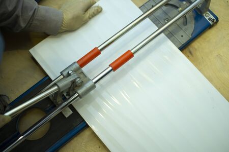 Tile cutter.Builder-tiler working with floor tile cutting equipment .の写真素材