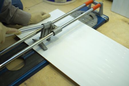 Tile cutter.Builder-tiler working with floor tile cutting equipmentの写真素材